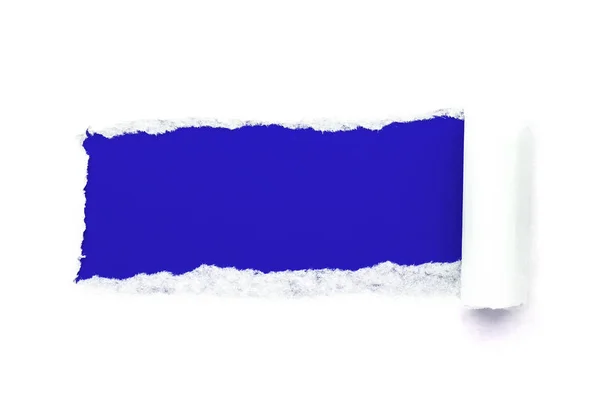Ein Loch in weißem Papier mit abgerissenen Rändern isoliert auf weißem Hintergrund mit dunkelblauem Papierhintergrund. gute Papierstruktur — Stockfoto