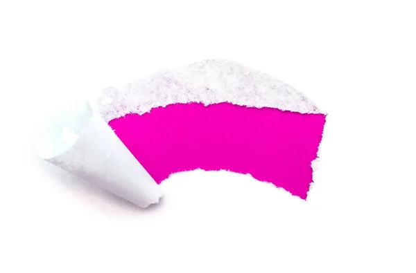 Ein Loch in weißem Papier mit abgerissenen Kanten isoliert auf weißem Hintergrund mit einem hellrosafarbenen Papierhintergrund innen. — Stockfoto
