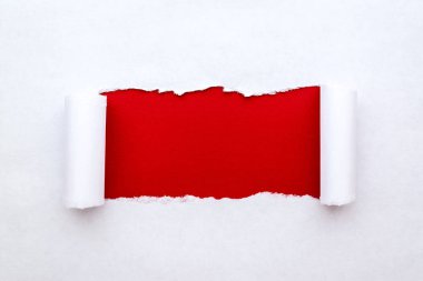 Beyaz kağıtta yırtık kenarlı, parlak kırmızı kağıtlı bir delik. Kağıt dokusu iyi.