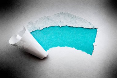 Yırtık kenarlı, içinde mavi gök mavisi arkaplanı olan eski bir kağıt parçası..