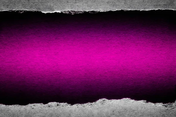 Ett hål i vintage papper med rivna kanter närbild med en rosa levande färg bakgrund inuti. — Stockfoto