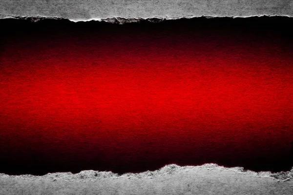 Ett hål i vintage papper med rivna kanter närbild med en röd levande färg bakgrund inuti. — Stockfoto