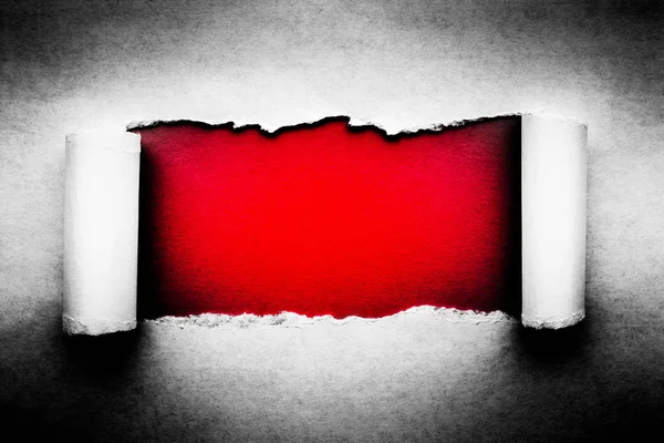 Дырка в винтажной бумаге с разорванными краями крупным планом с красным вибратором — стоковое фото