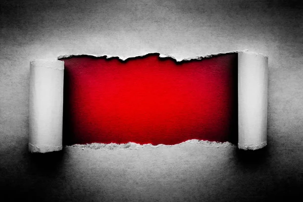 Egy lyuk a vintage papír szakadt élek közelkép egy piros élénk színes háttér belül. — Stock Fotó
