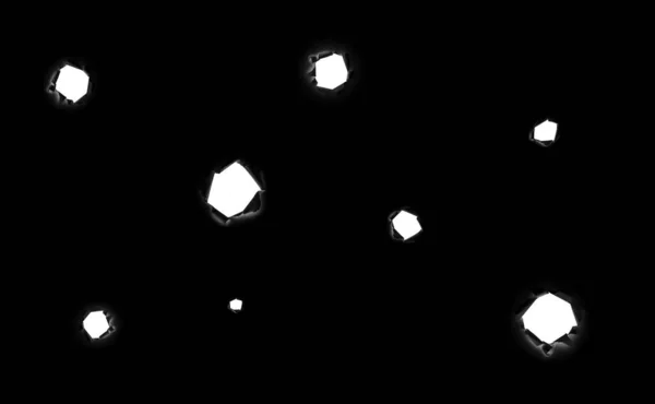 A lot of torn round holes of different sizes in black paper as if from bullets with a white background inside, isolated on a black background. Bullet holes. — Stock Photo, Image