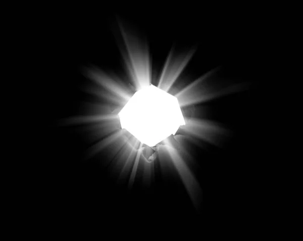 Odizolowana okrągła dziura w czarnym papierze z rozdartymi krawędziami, przebitym słońcem i promieniami. Słońce przebija się przez ciemność z dziury. — Zdjęcie stockowe