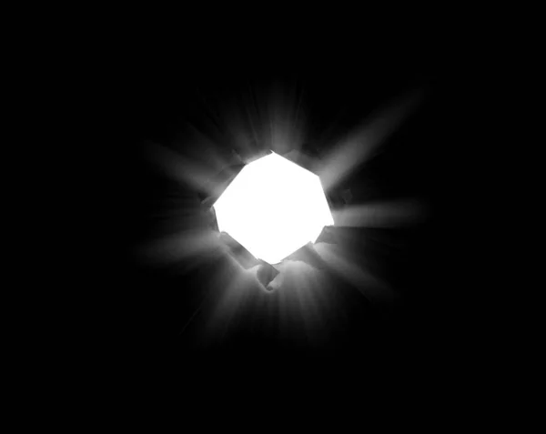 Um buraco redondo isolado em papel preto com bordas rasgadas e luz solar perfurante e raios através dele. Luz solar rompendo a escuridão de um buraco . — Fotografia de Stock