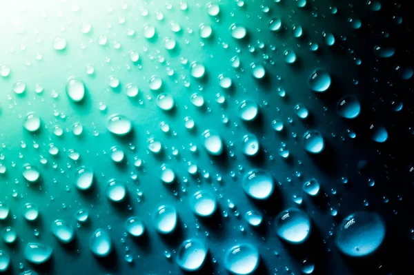Druppels water met een mooie gladde gradiënt close-up macro op het materiaal in het zonlicht. — Stockfoto