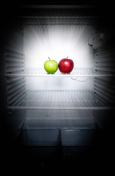 Концептуальне творче фото світяться в темних свіжих червоних і зелених яблуках у відкритому порожньому холодильнику. Концепція дієти втрати ваги . — стокове фото