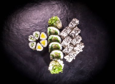 Koyu renkli bir arka planda farklı bir vejetaryen suşi seti..