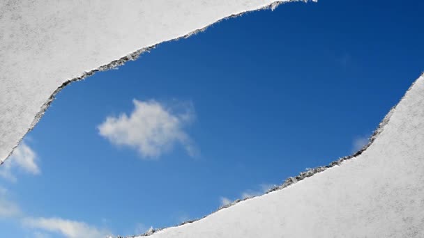 在旧复古复古纸片的边缘被撕破的洞里 可以看到蓝天中快速移动的云彩 创造性的时间在画面上打转 — 图库视频影像