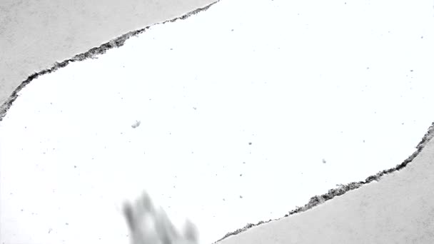 通过旧复古复古纸撕破边缘的孔中可以看到的缓慢降雪的创造性慢动作视频 — 图库视频影像