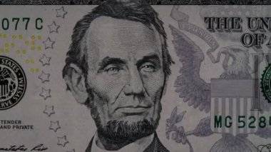 Abraham Lincoln 'ün yakın plan portresi, parlayan gözlerinin ve 1 dolarlık banknotun piramidinin etkisiyle beş Amerikan doları banknotunun yaratıcı 4K videosu. 5 dolarlık banknotun detayları.