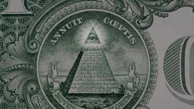 1 Amerikan Doları 'na ait bir makro banknotun piramitli 4k' lik yaratıcı videosu ve üzerinde ışıldayan bir mason gözün etkisi. Piramit, 1 Amerikan Doları 'na yakın çekim..