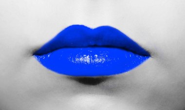 Siyah ve beyaz bir arkaplanda koyu mavi ruj ve parlak sulu bir renge sahip kadın dudakları..