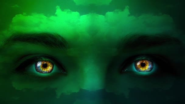 カラフルな目と彼女の顔に移動雲のパターンと緑の色のクローズアップの神秘的な女性の顔の創造的な4Kビデオ 謎の表情だ 暗闇の中で目を輝かせる — ストック動画