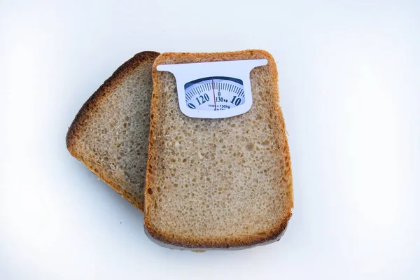 Imaginary weighing scales made of bread slice isolated on white background. Diet concept to promote healthy eating and weight management.
