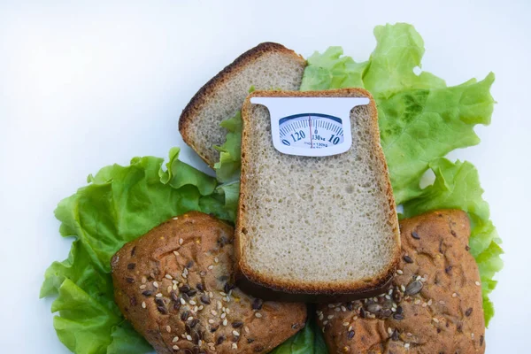 Imaginary weighing scales made of bread slice isolated on white background. Diet concept to promote healthy eating and weight management.