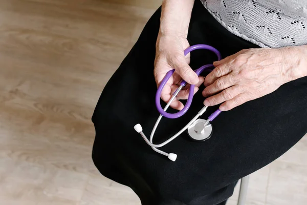 Mormor håller ett stetoskop i hand — Stockfoto