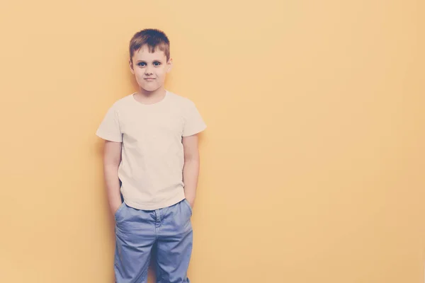 黄色の壁の背景にきれいな男の子 — ストック写真
