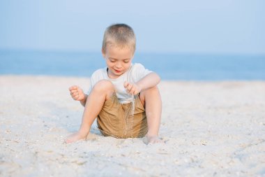 Portre kum deniz kenarında oynarken mutlu küçük çocuk okyanus. Olumlu insan duyguları, duygular, joy. Vacations ayırdığınız ve yaz zevk komik şirin çocuk.