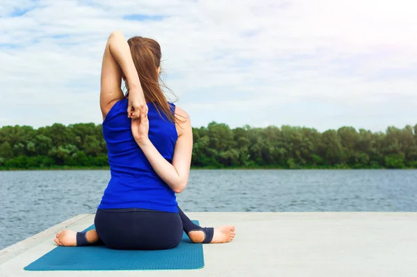 Mujer joven haciendo ejercicio de yoga en la estera 16 — Foto de Stock