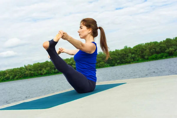 Mujer joven haciendo ejercicio de yoga en la estera 18 — Foto de Stock
