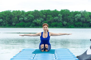 Genç kadının mat 27 Yoga egzersiz yapması