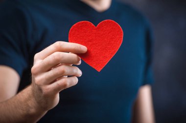 Kırmızı kalp tatil için holding ile genç komik adam