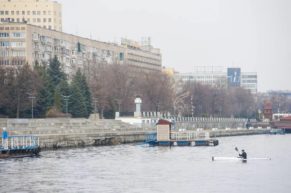 Un hombre en un kayak blanco cerca de la orilla del río de la ciudad01 —  Fotos de Stock