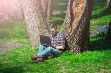 Genç adam bir bahar park02 içinde laptop ile çalışma
