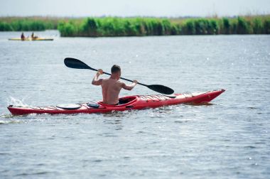 adam bir kırmızı kayık 01 yüzüyor