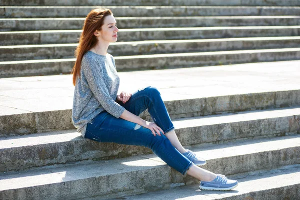 Девушка, сидящая на каменных ступеньках 01 — стоковое фото