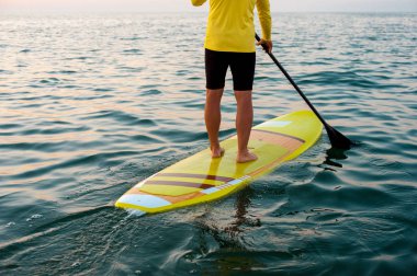 Gün batımı 03, yatılı atletik adam kürek silüeti sup