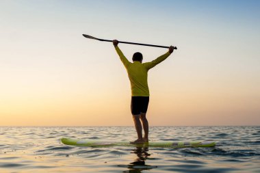 Gün batımı 09 yatılı atletik adam kürek silüeti sup