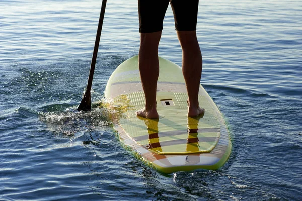 Gün batımı 16, yatılı atletik adam kürek silüeti sup
