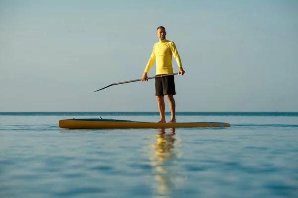 SUP silueta de hombre atlético paddle boarding al atardecer 21 — Foto de Stock