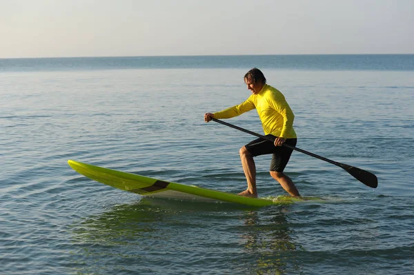 Silhouette SUP d'homme athlétique planche à pagaie au coucher du soleil 23 — Photo