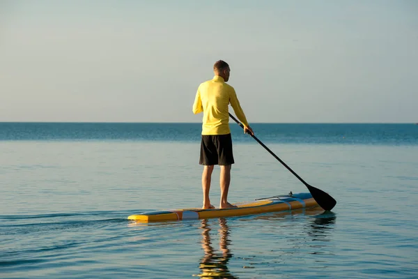 SUP silhouette di uomo atletico paddle boarding al tramonto 20 — Foto Stock