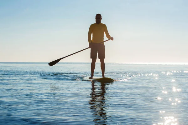 SUP silueta de hombre atlético paddle boarding al atardecer 29 — Foto de Stock
