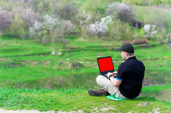 Jovem com laptop trabalhando ao ar livre — Fotografia de Stock