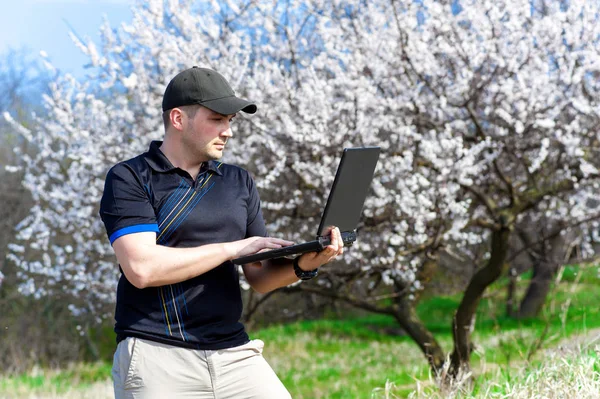 Mladý muž s notebookem pracovat venku — Stock fotografie