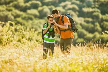 Baba ve oğul doğada yaz aylarında hiking. Çocuk fotoğraf çekimi. 