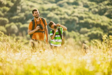 Baba ve oğul doğada yaz aylarında hiking. Çocuk fotoğraf çekimi. 