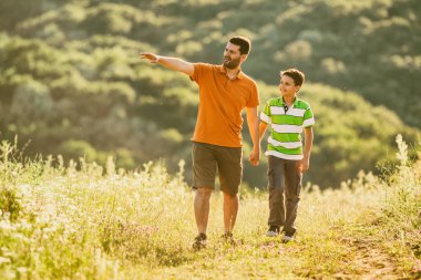 Baba ve oğul doğada yaz aylarında yürüyor. 