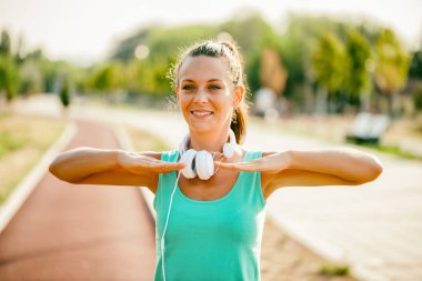 Genç kadın güneşli günde egzersiz olduğunu. O vücudu germe.