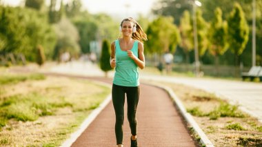 Genç kadın güneşli günde koşu. 