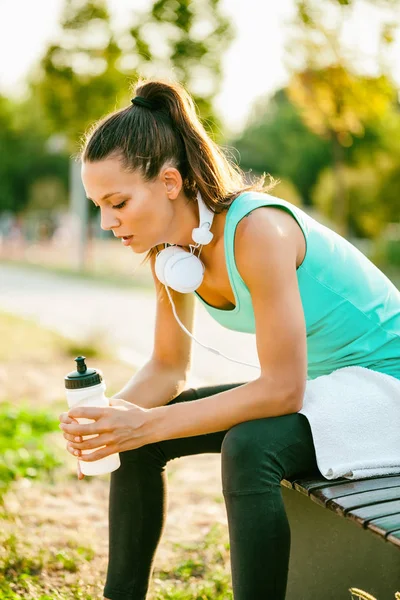 若い女性はジョギングの後リラックスと飲料水 — ストック写真