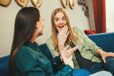 İki mutlu kadın cafede oturan ve söz.