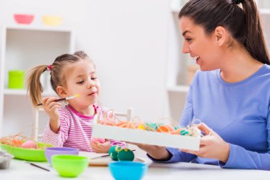 Mutlu anne ve kızı için Paskalya yumurta boyama.